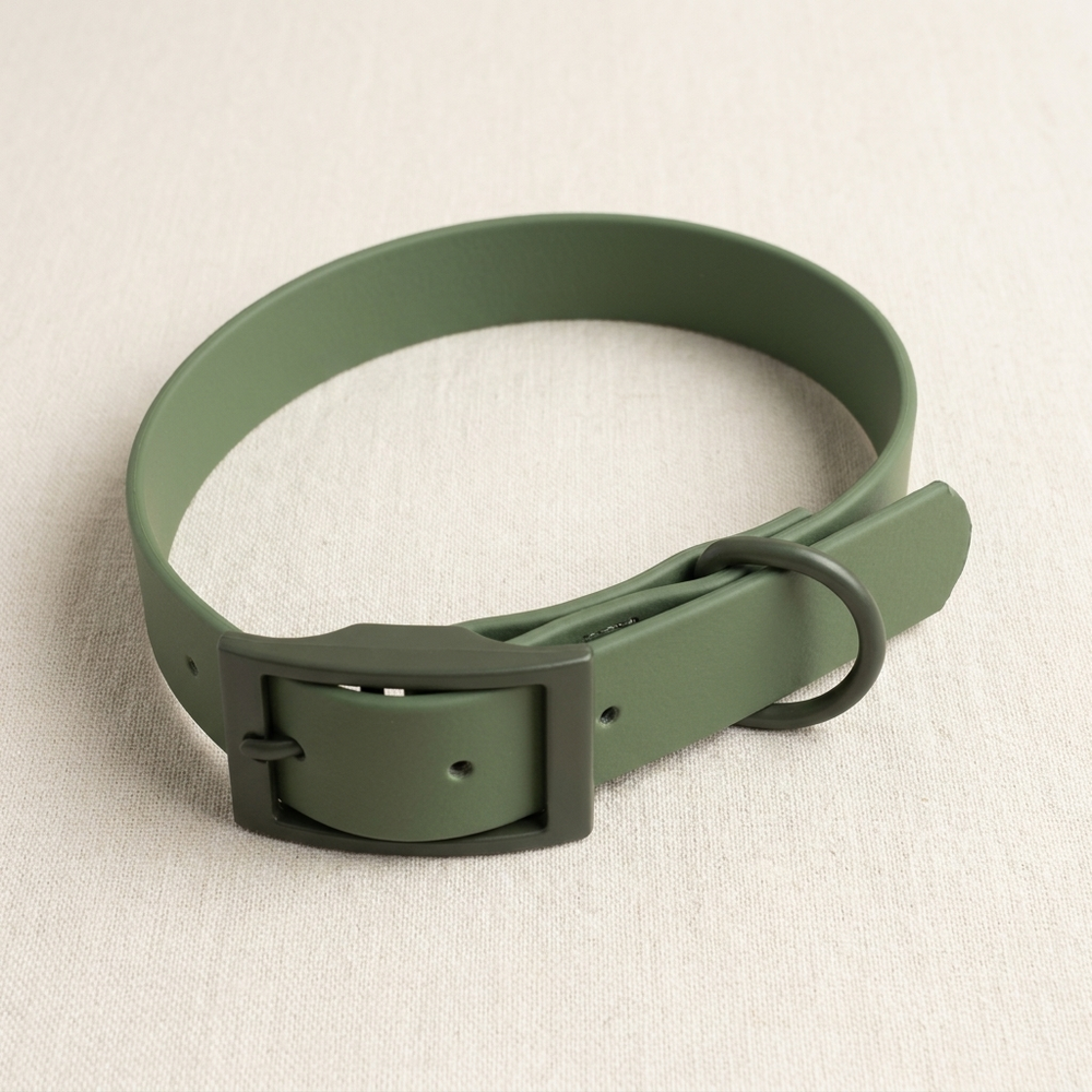 A moss-green coated waterproof dog collar with matte buckle and D-ring, on cream linen