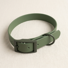 A moss-green coated waterproof dog collar with matte buckle and D-ring, on cream linen