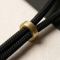 Close-up of a black waxed rope slip lead with a solid brass slider ring